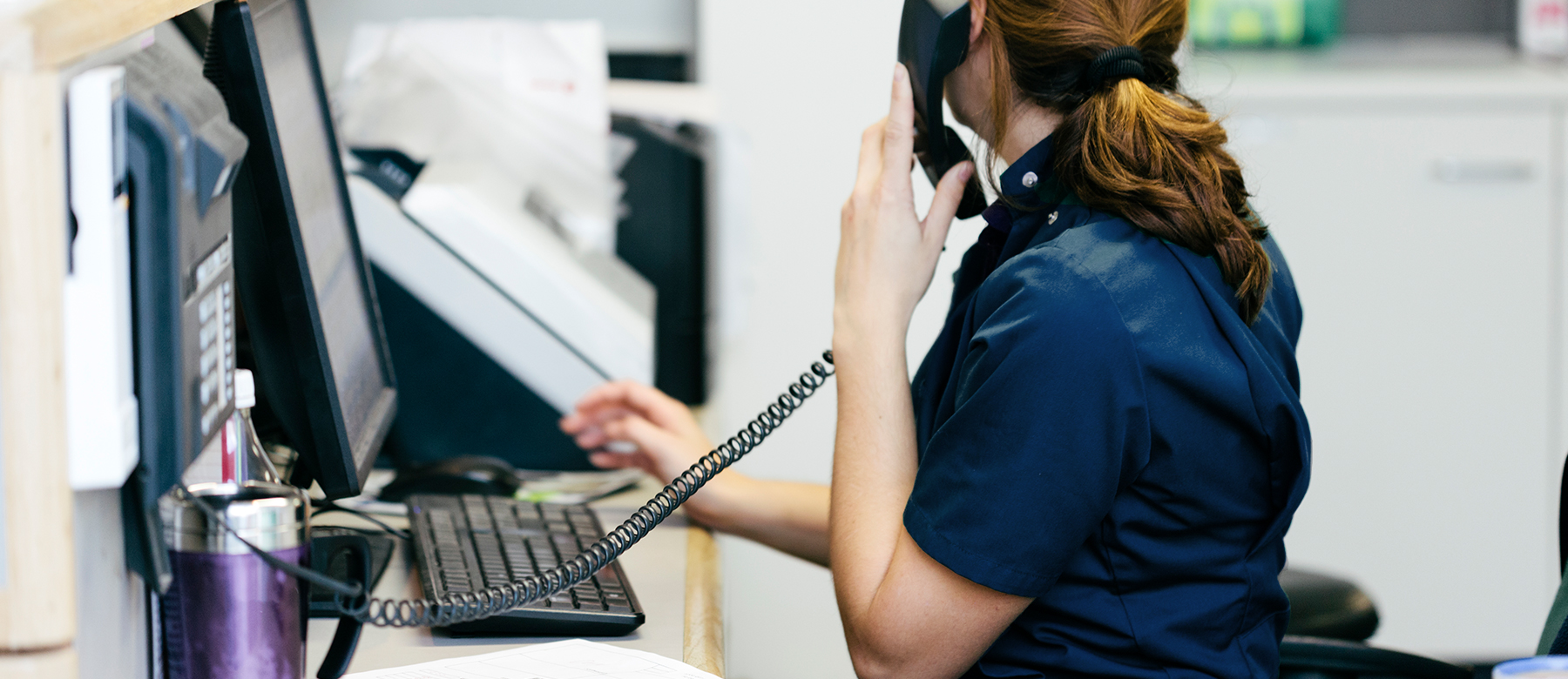 Resepsjonist ved dyreklinikk prater i telefonen